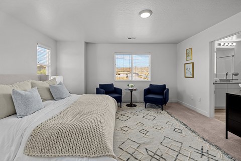 a bedroom with a large bed and two chairs