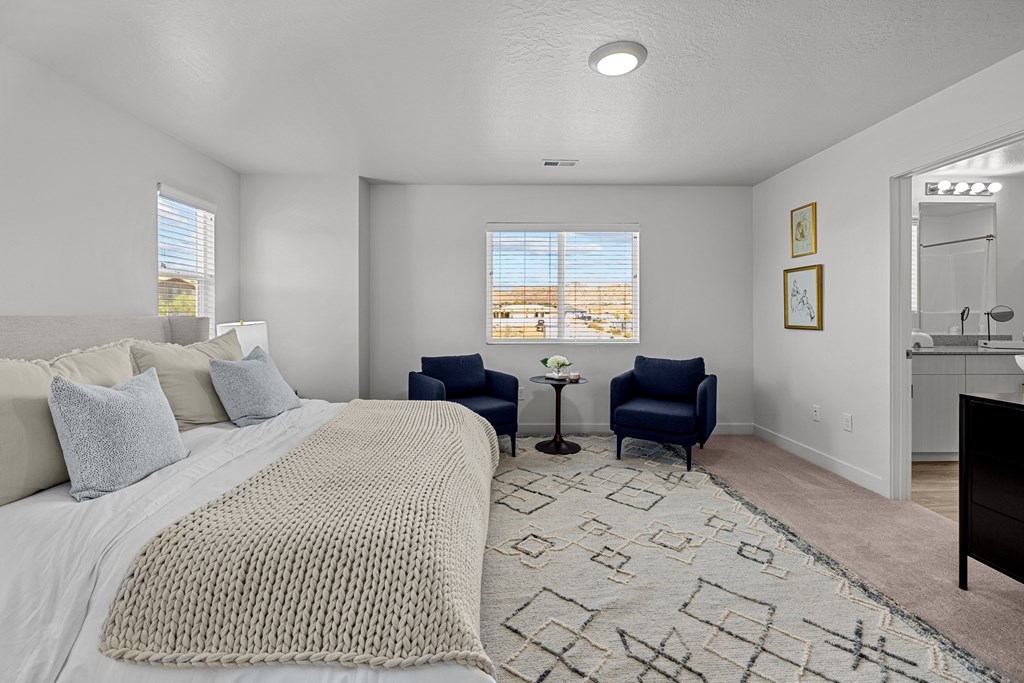 a bedroom with a large bed and two chairs