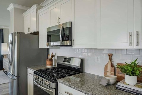 A modern kitchen with a stove top oven and microwave above it.
