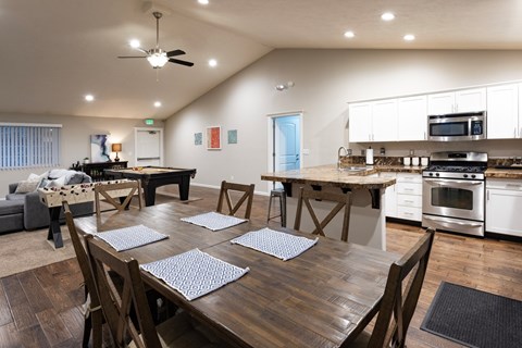 A modern dining room with a large wooden table and chairs.