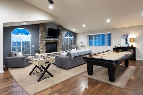 A pool table is in the middle of a living room.
