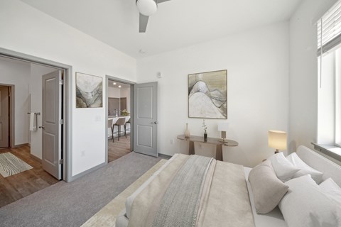 A bedroom with a large bed and a painting on the wall.