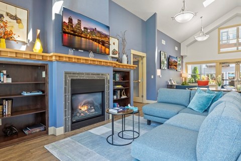 A living room with a fireplace and a painting of a city skyline on the wall.