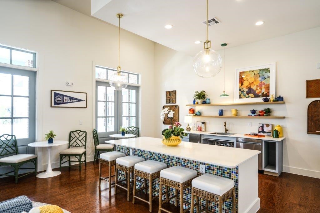 A kitchen with a white island and blue chairs.