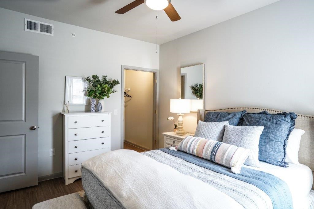 A bedroom with a bed, dresser, and mirror.