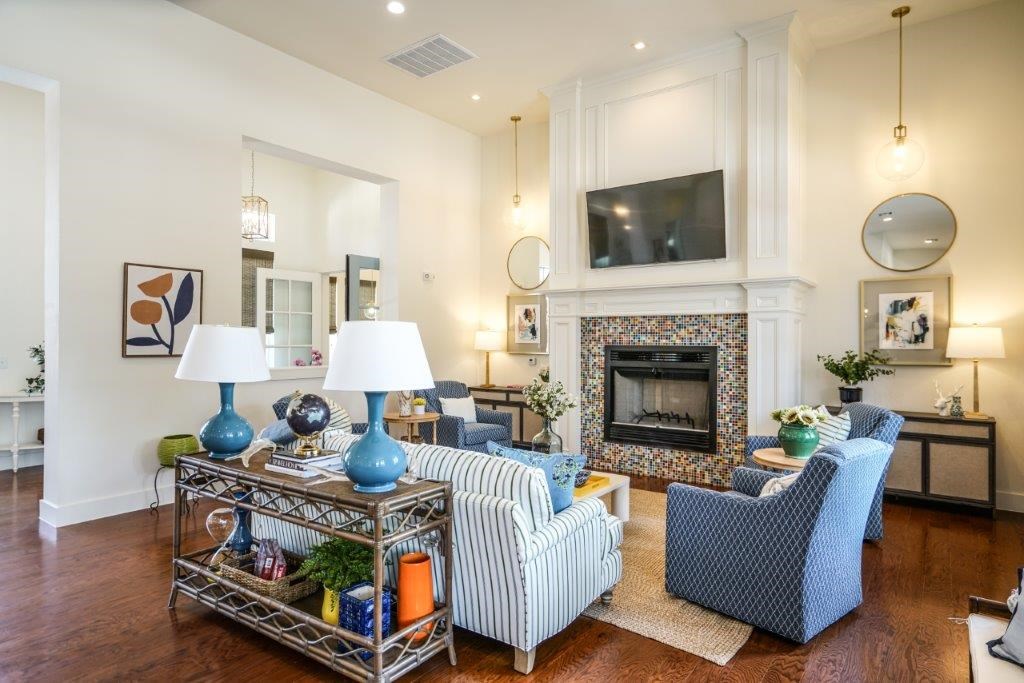 A living room with a fireplace and a TV mounted above it.