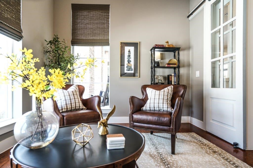 A living room with a brown leather chair and a black coffee table.