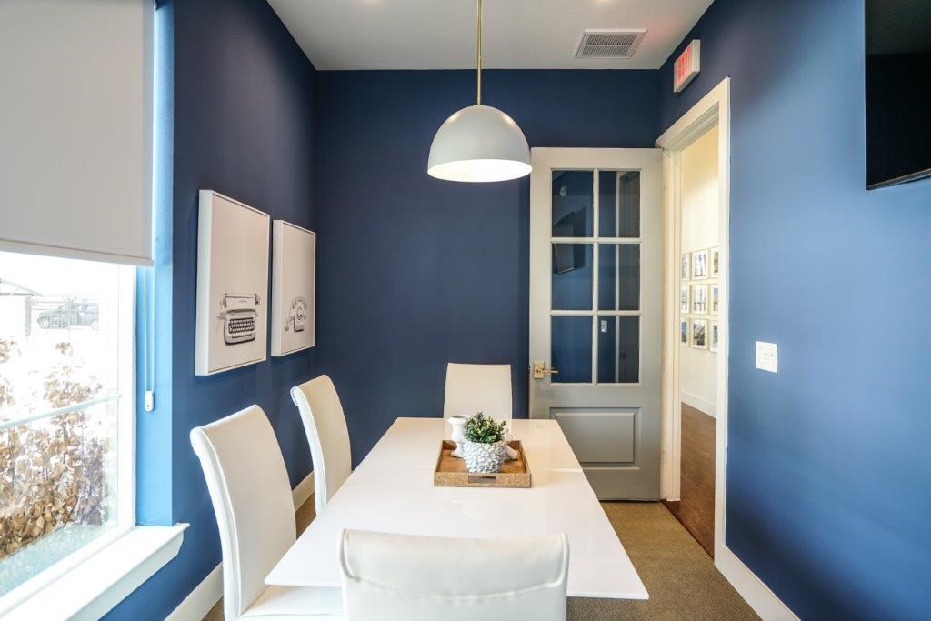 A dining room with a white table and chairs.