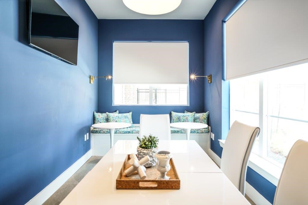 A dining room with a white table and chairs.