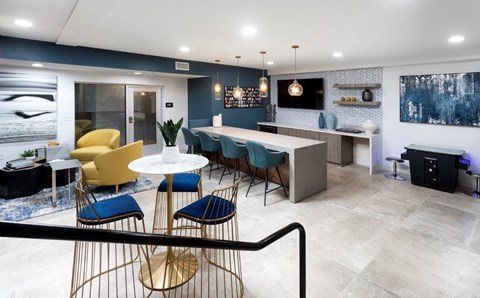 A modern dining area with a white table and blue chairs.