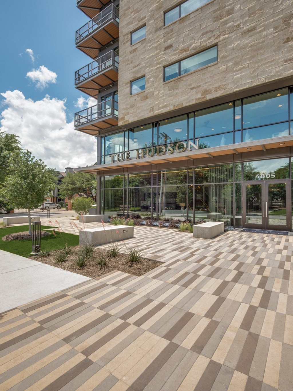 a large stone building with glass windows and a stone walkway in front of it