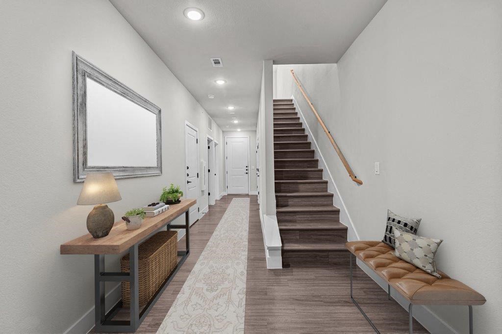 a living room with a staircase and a table with chairs