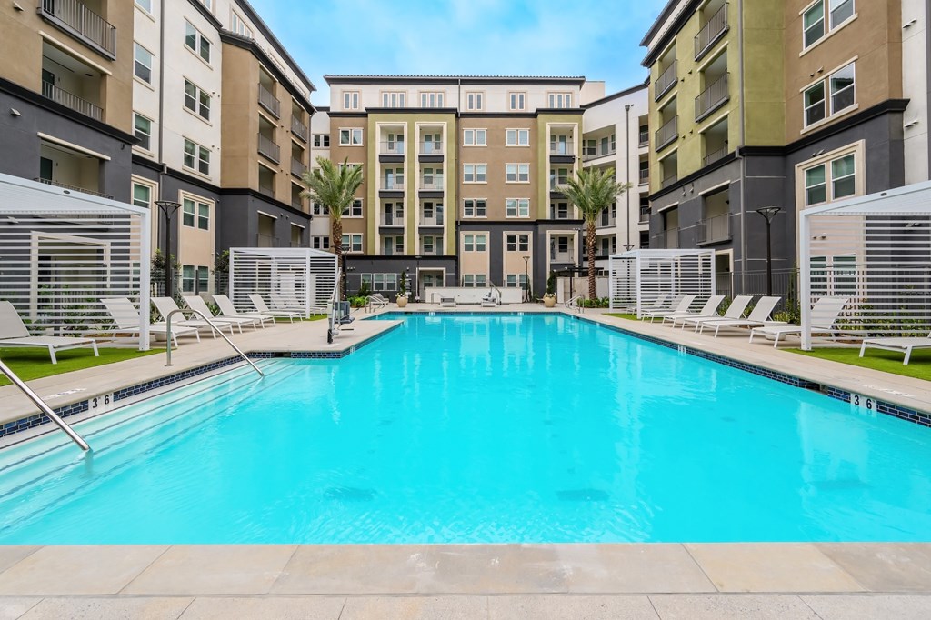 A large swimming pool in front of apartment buildings.