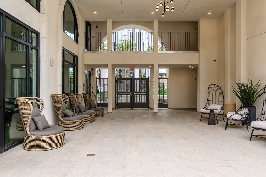A spacious atrium with wicker chairs and a glass door.
