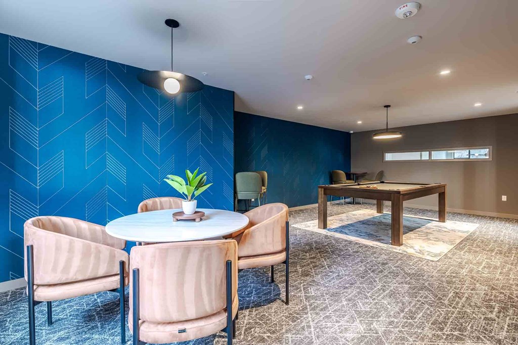 A blue patterned wall with a table and chairs in front of it.