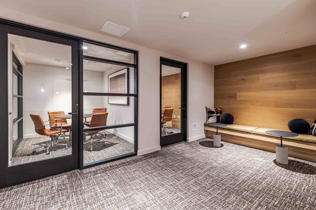 A room with a carpeted floor and a bench with a wooden wall behind it.