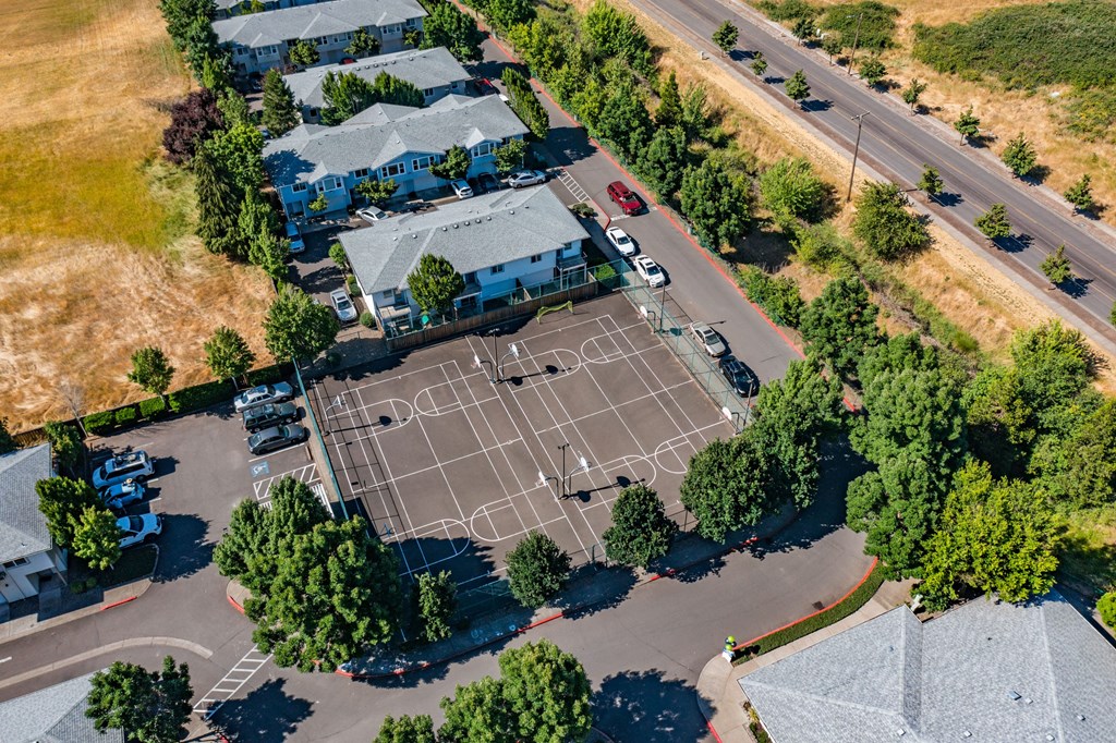 an aerial view of a tennis court in a residential neighborhood