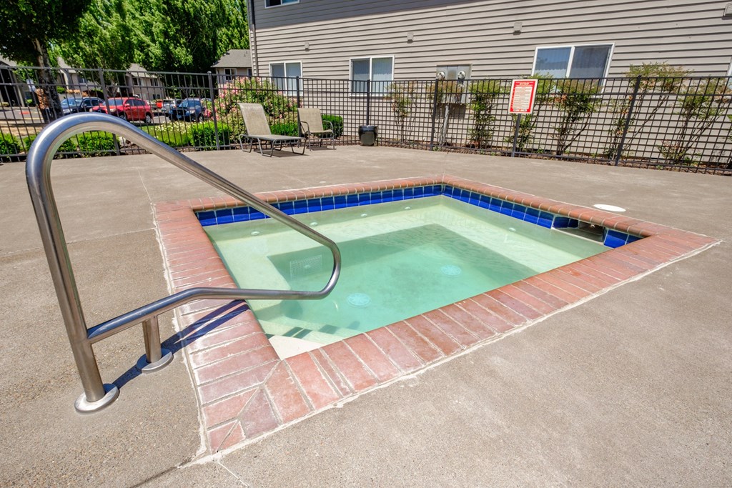 a hot tub sits in the middle of a concrete patio