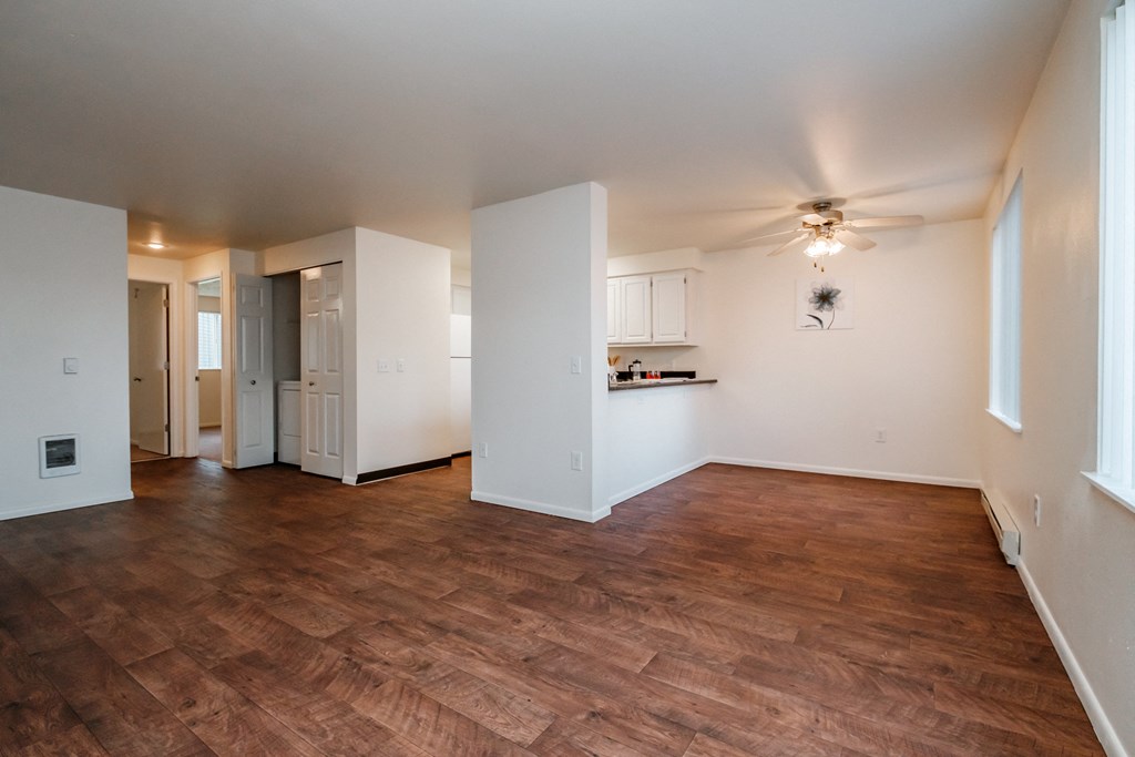 an empty living room with a ceiling fan