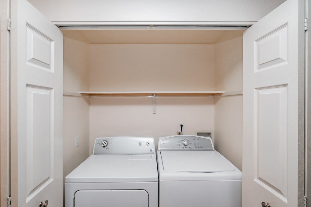 a washer and dryer in a laundry room with white doors