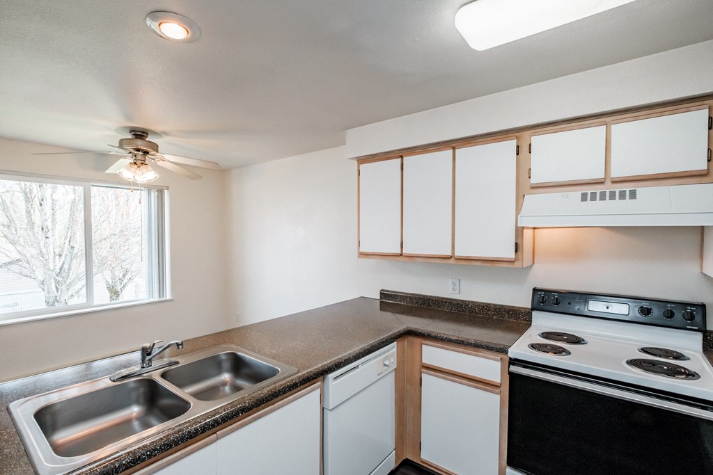a kitchen with white cabinets and a black stove top oven