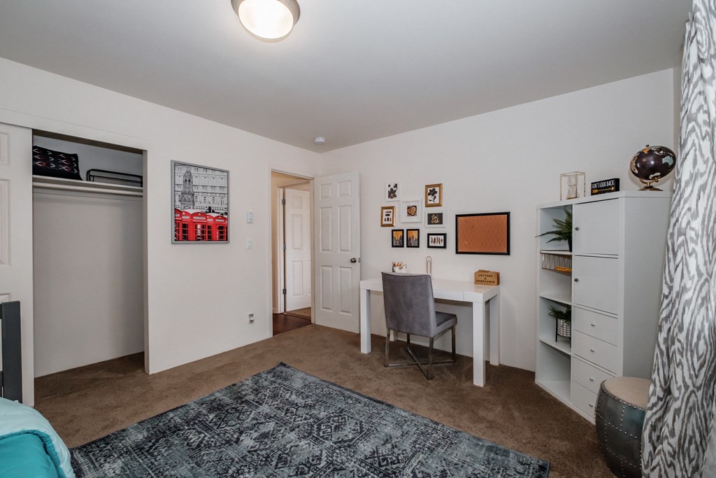 a bedroom with a desk and a closet