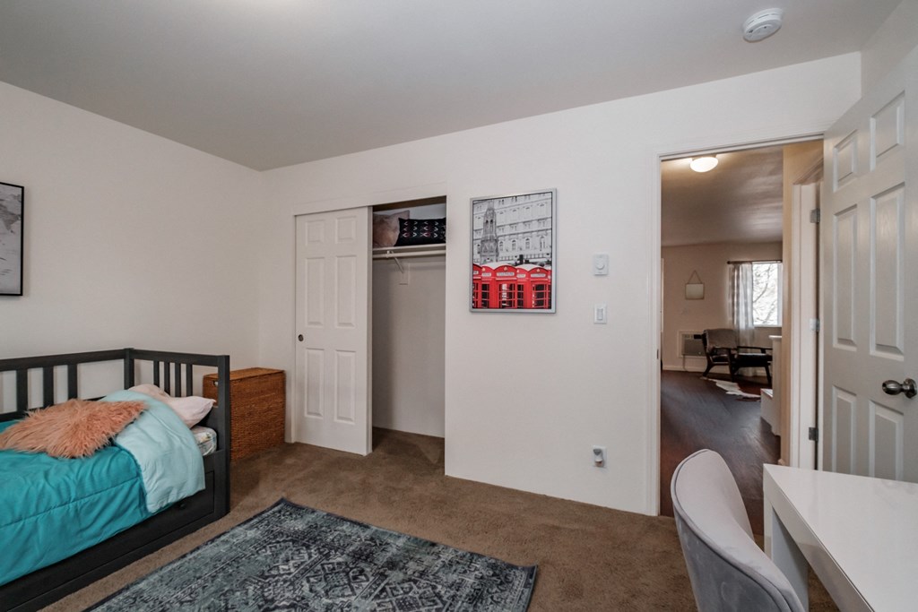 a bedroom with a bed and a desk