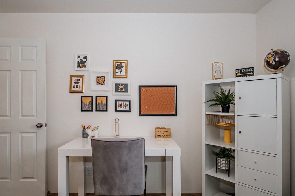 a home office with a white desk and a grey chair
