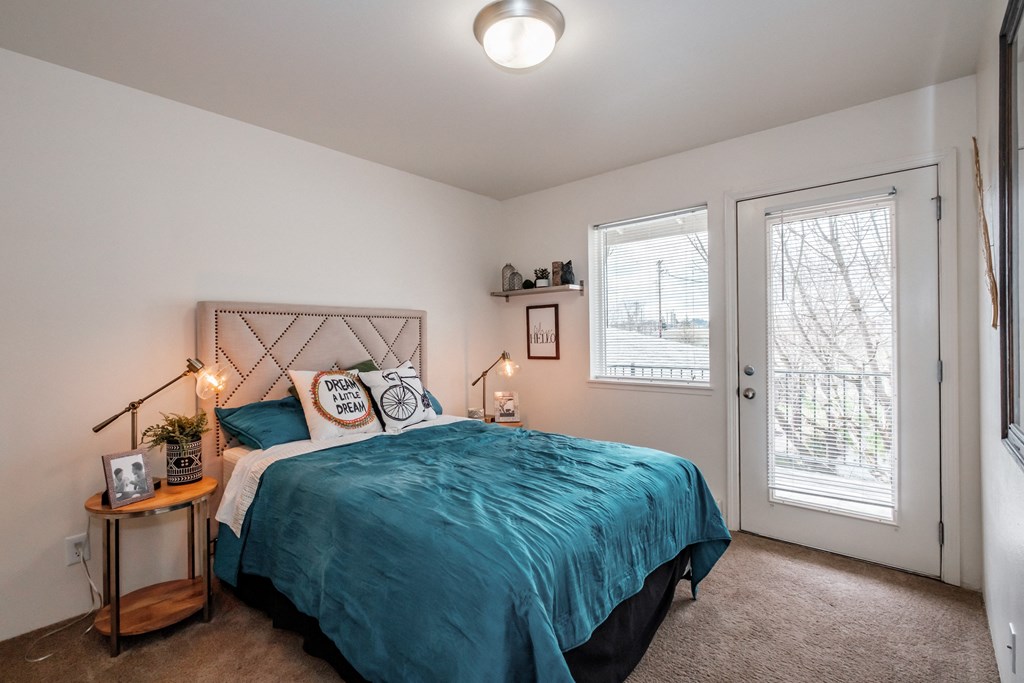 a bedroom with a bed and two windows