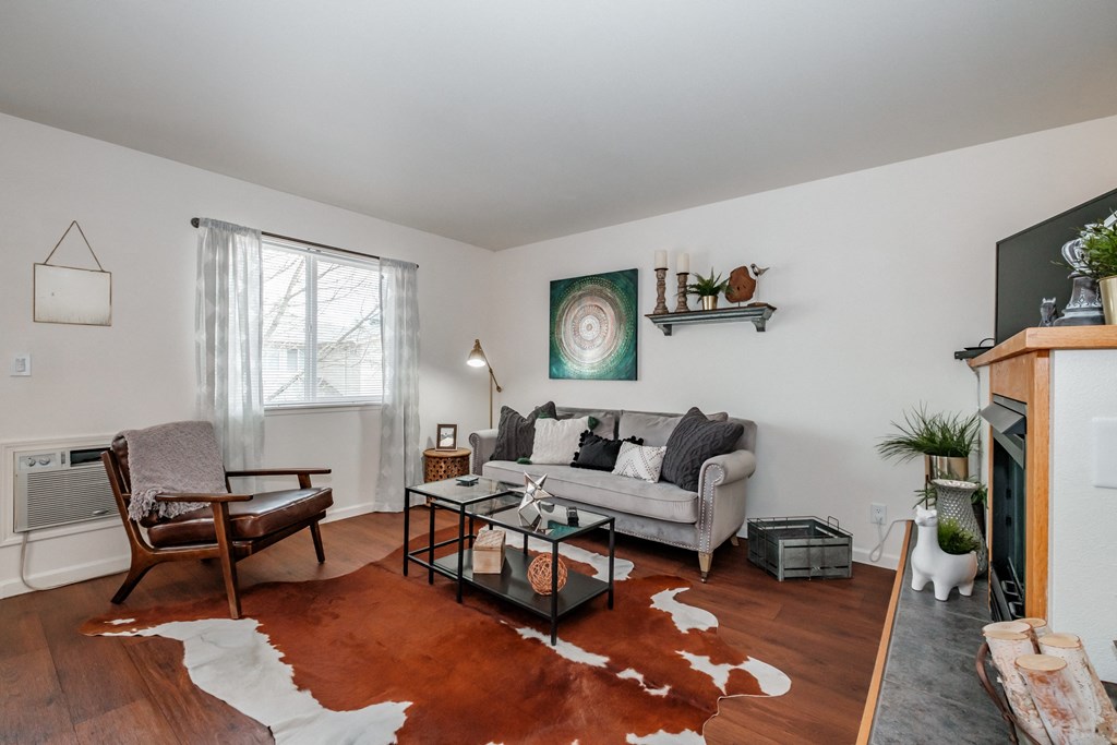 a living room with white walls and hardwood floors