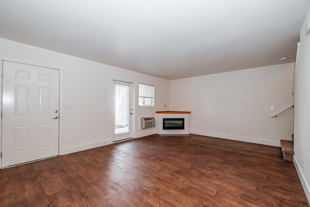 a living room with hardwood floors and white walls
