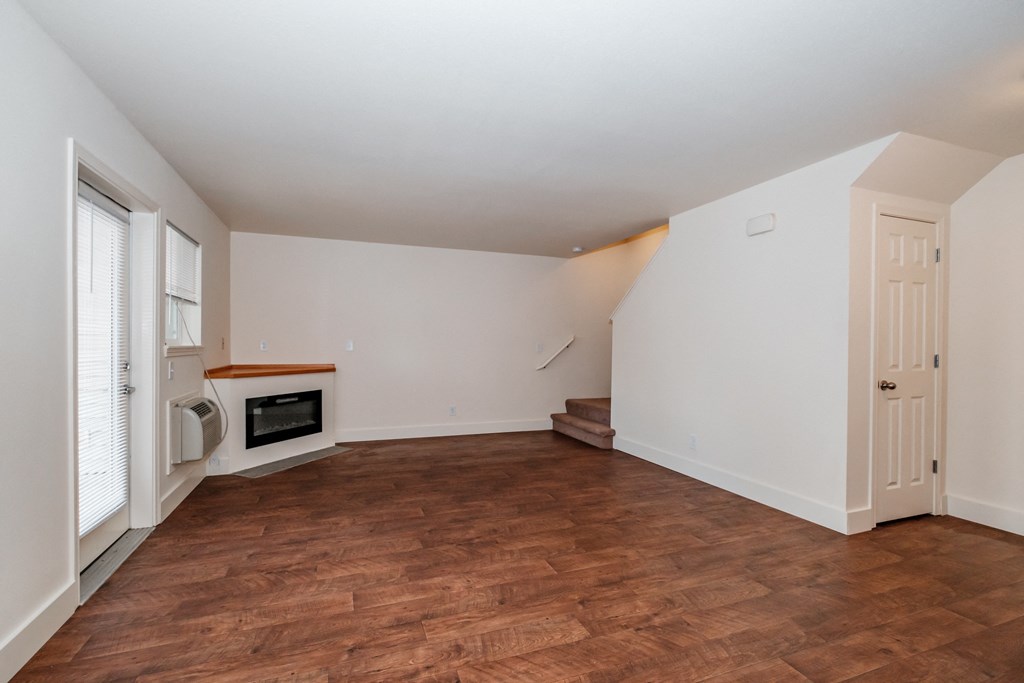 a living room with white walls and a wooden floor