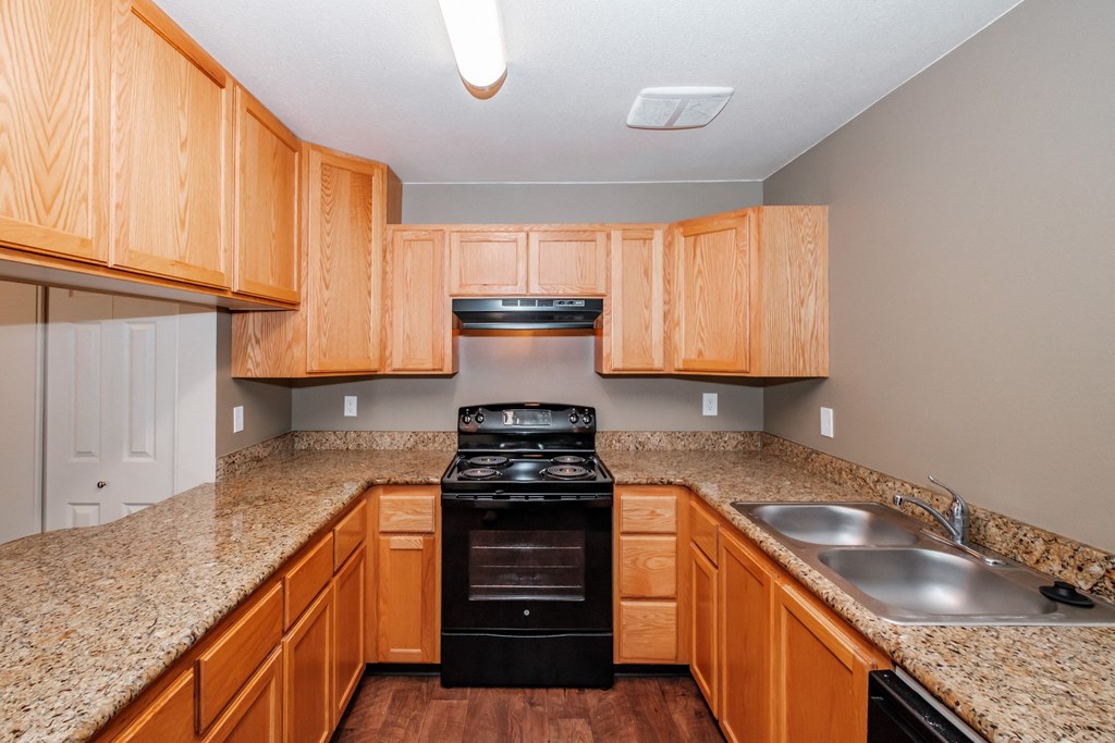 a kitchen with wood cabinets and granite countertops