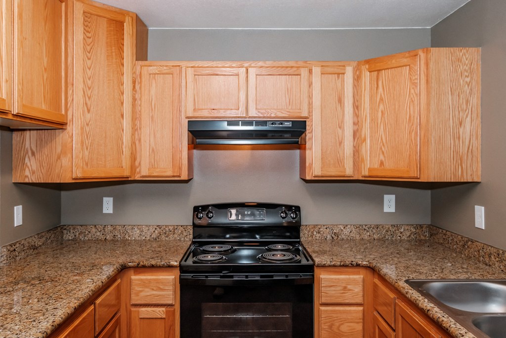 a kitchen with wooden cabinets and granite countertops