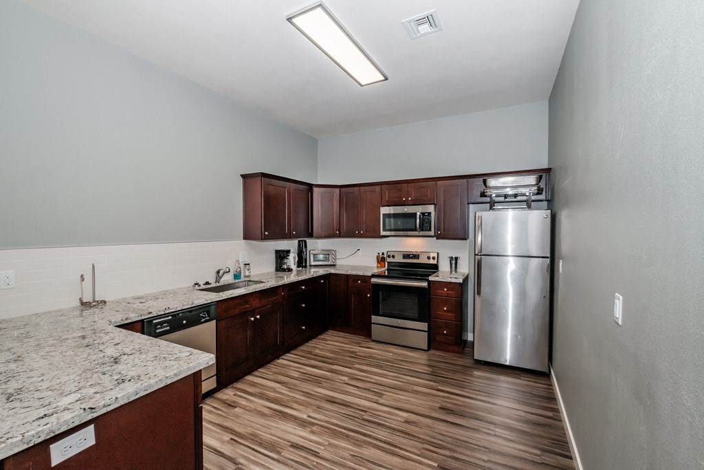 a kitchen with wood floors and stainless steel appliances
