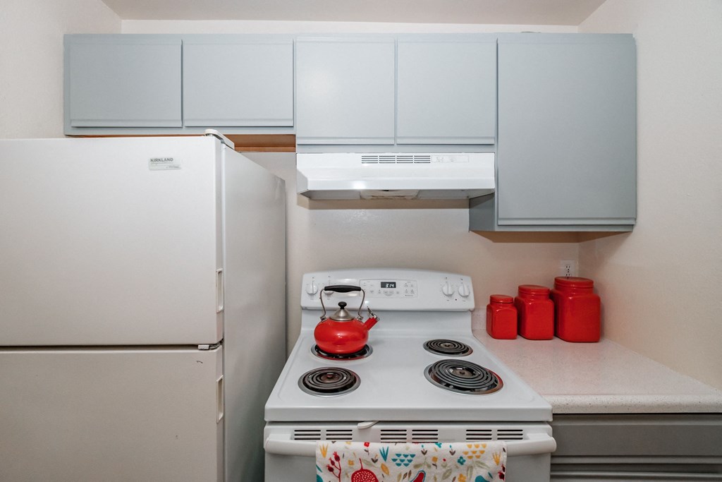 a small kitchen with a white stove and refrigerator