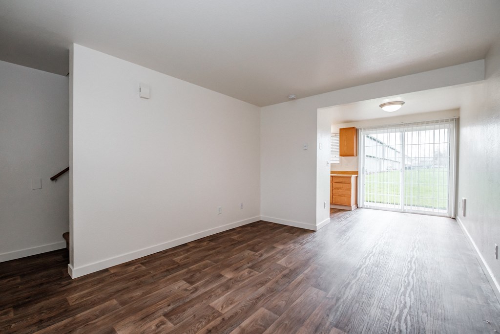 a bedroom with hardwood floors and white walls
