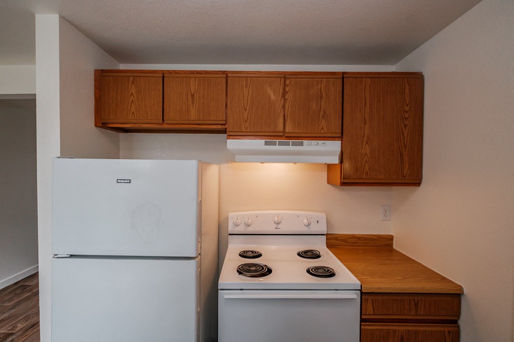 a kitchen with white appliances and wooden cabinets