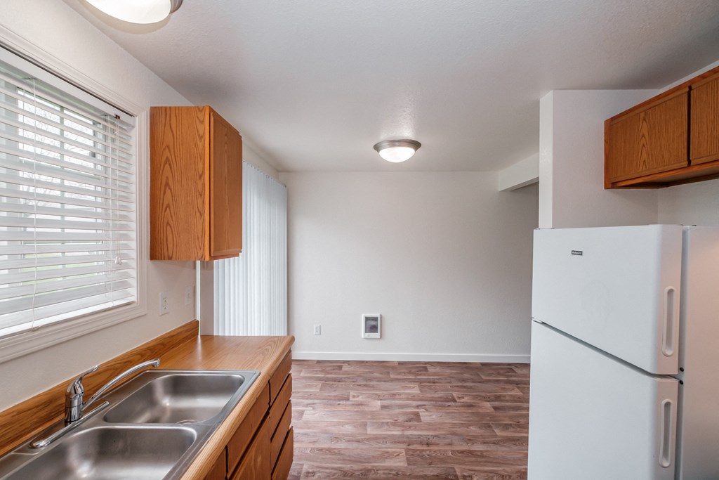 a kitchen with wood cabinets and a stainless steel sink