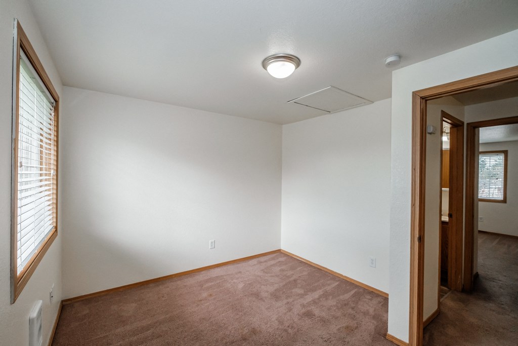 a bedroom with white walls and a carpeted floor