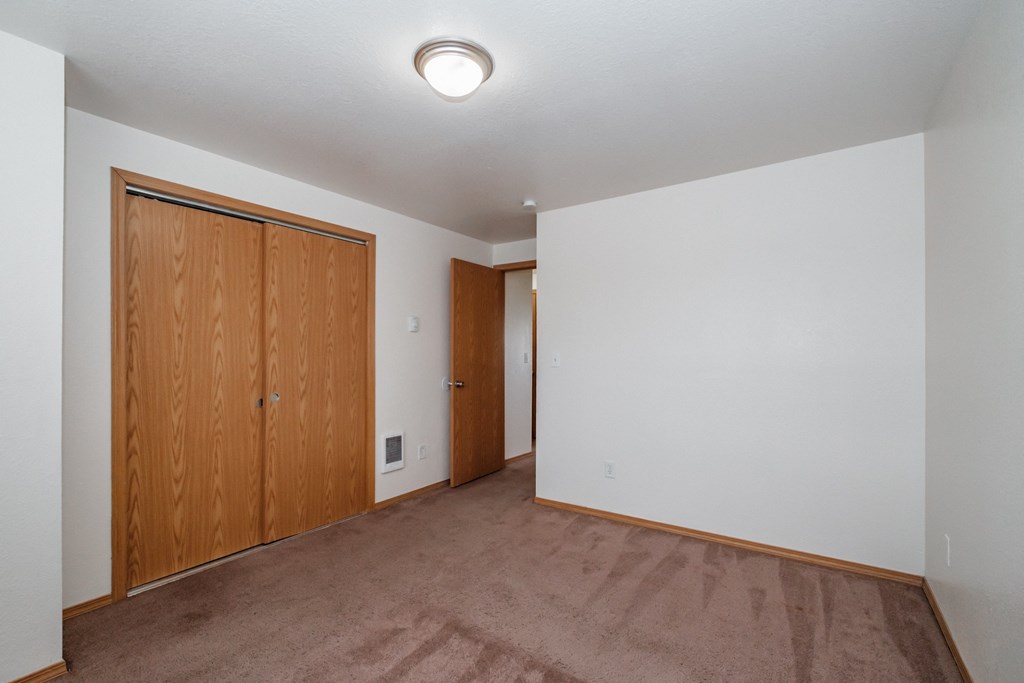 a bedroom with a carpeted floor and white walls
