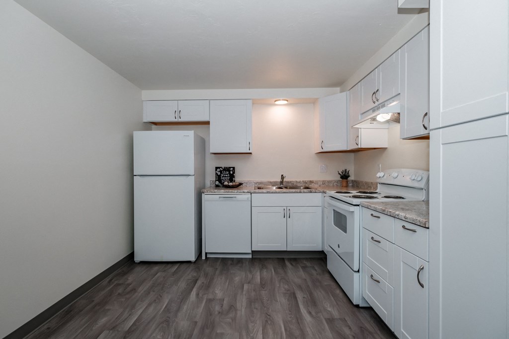 a kitchen with white cabinets and a white refrigerator