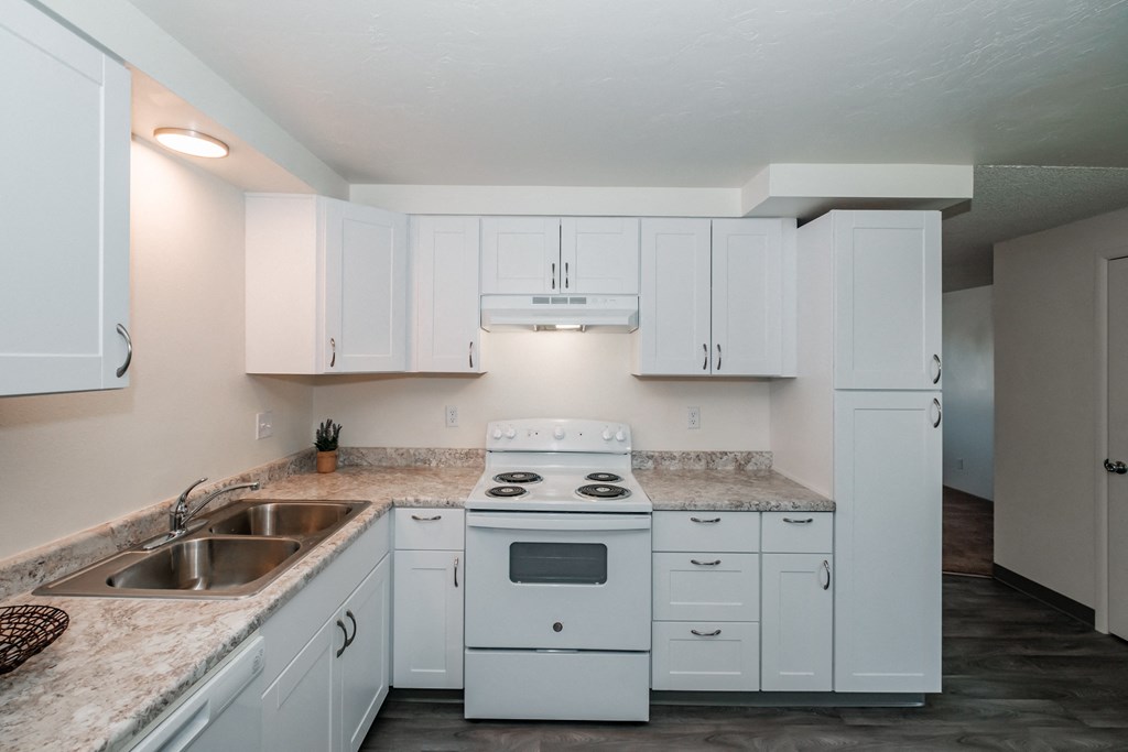 a kitchen with white cabinets and a white stove top oven