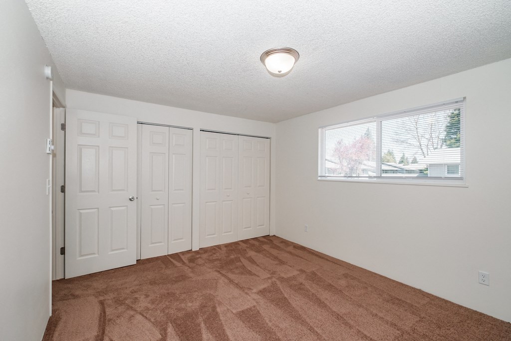 a bedroom with two closets and a window