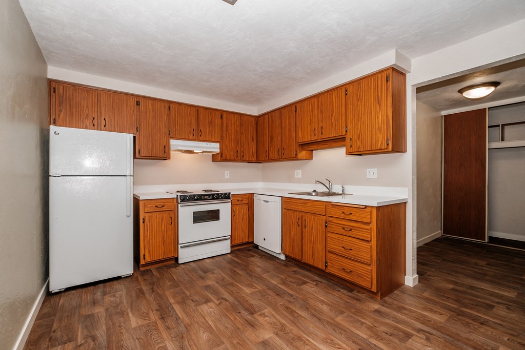 a kitchen with white appliances and wooden cabinets