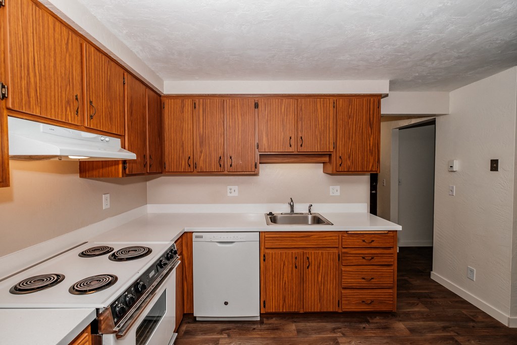 a kitchen with white appliances and wooden cabinets
