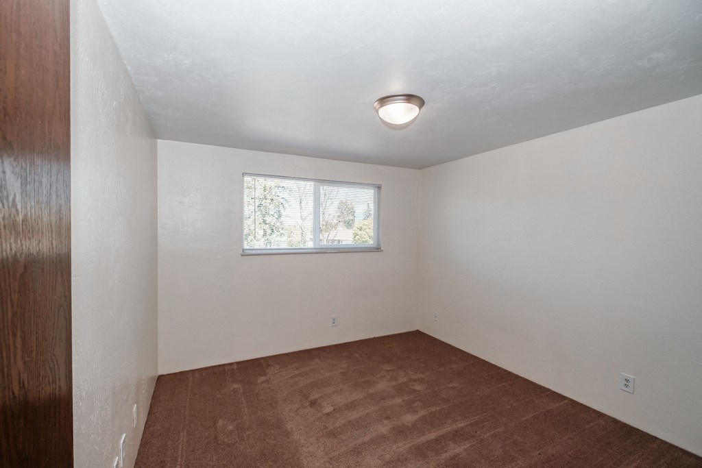 a small room with white walls and a small window
