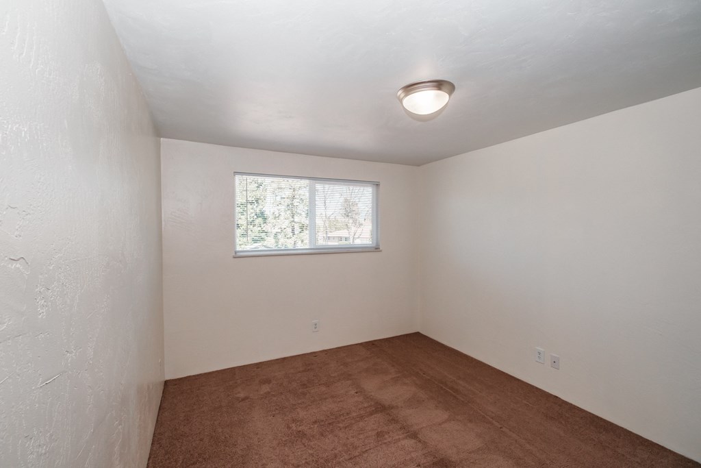 a small room with white walls and a small window