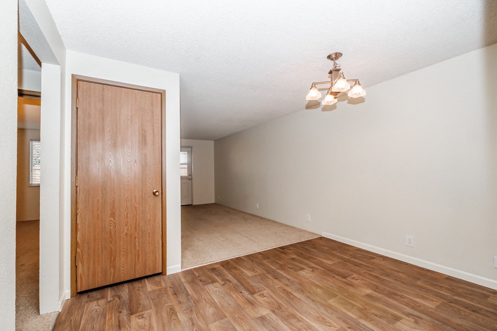 a living room with hardwood floors and a wooden door