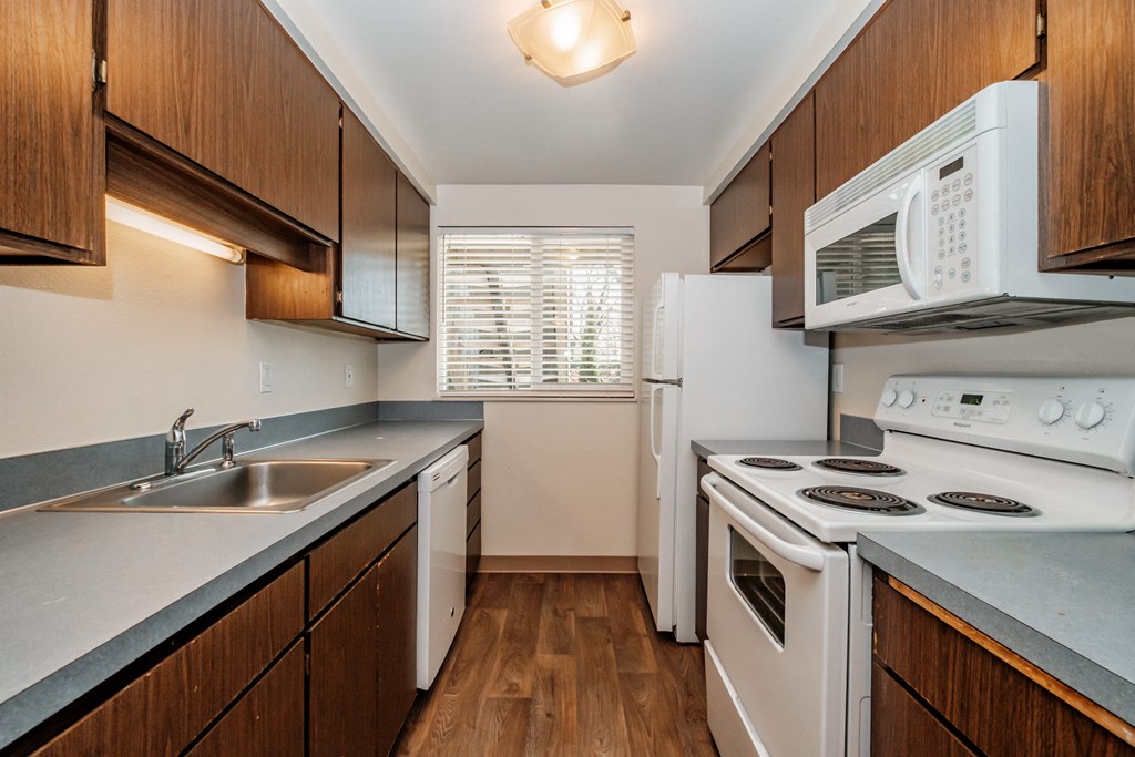 a kitchen with white appliances and wooden cabinets